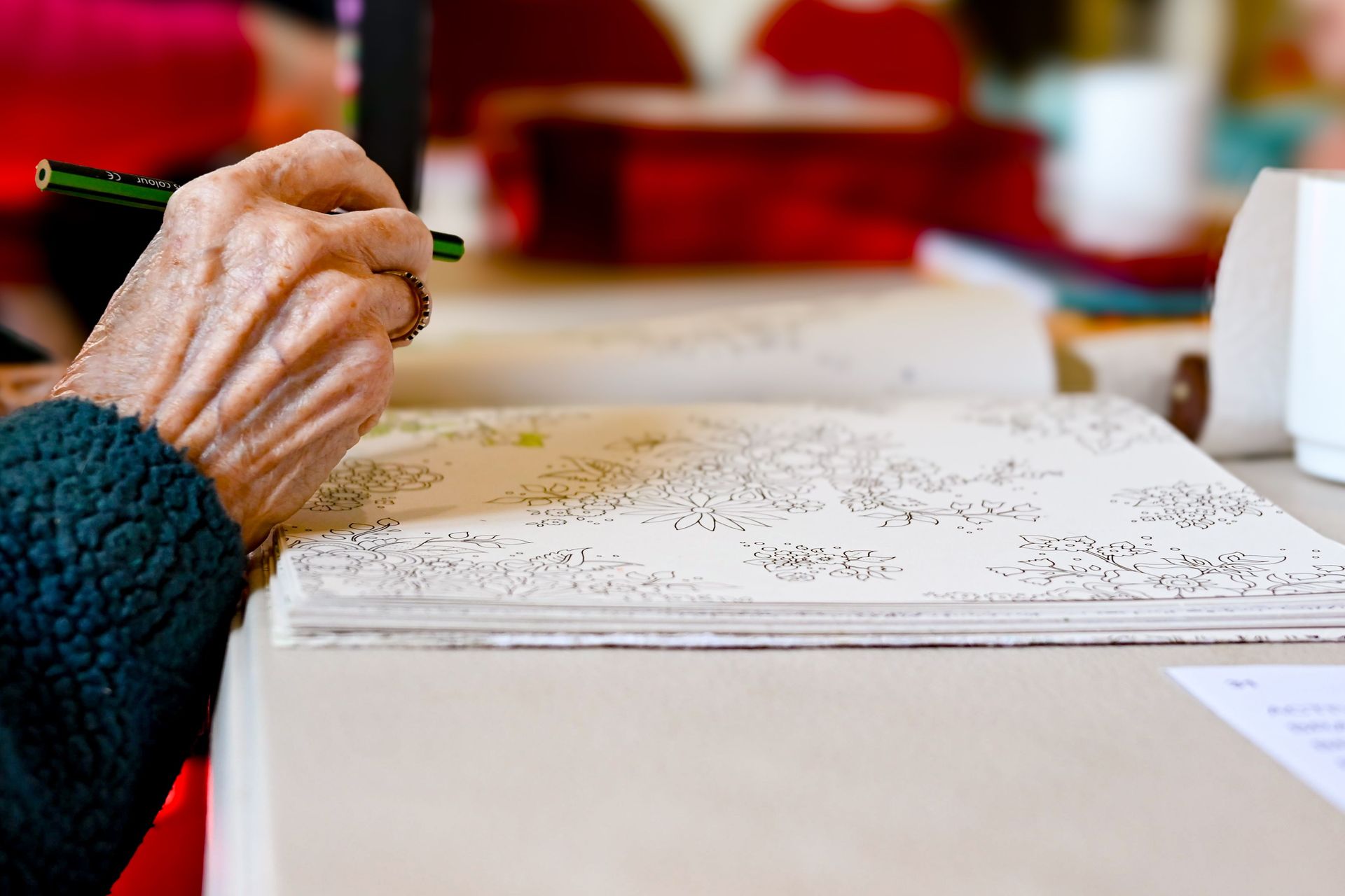 A senior adult coloring intricate designs, showcasing hand creativity and concentration.